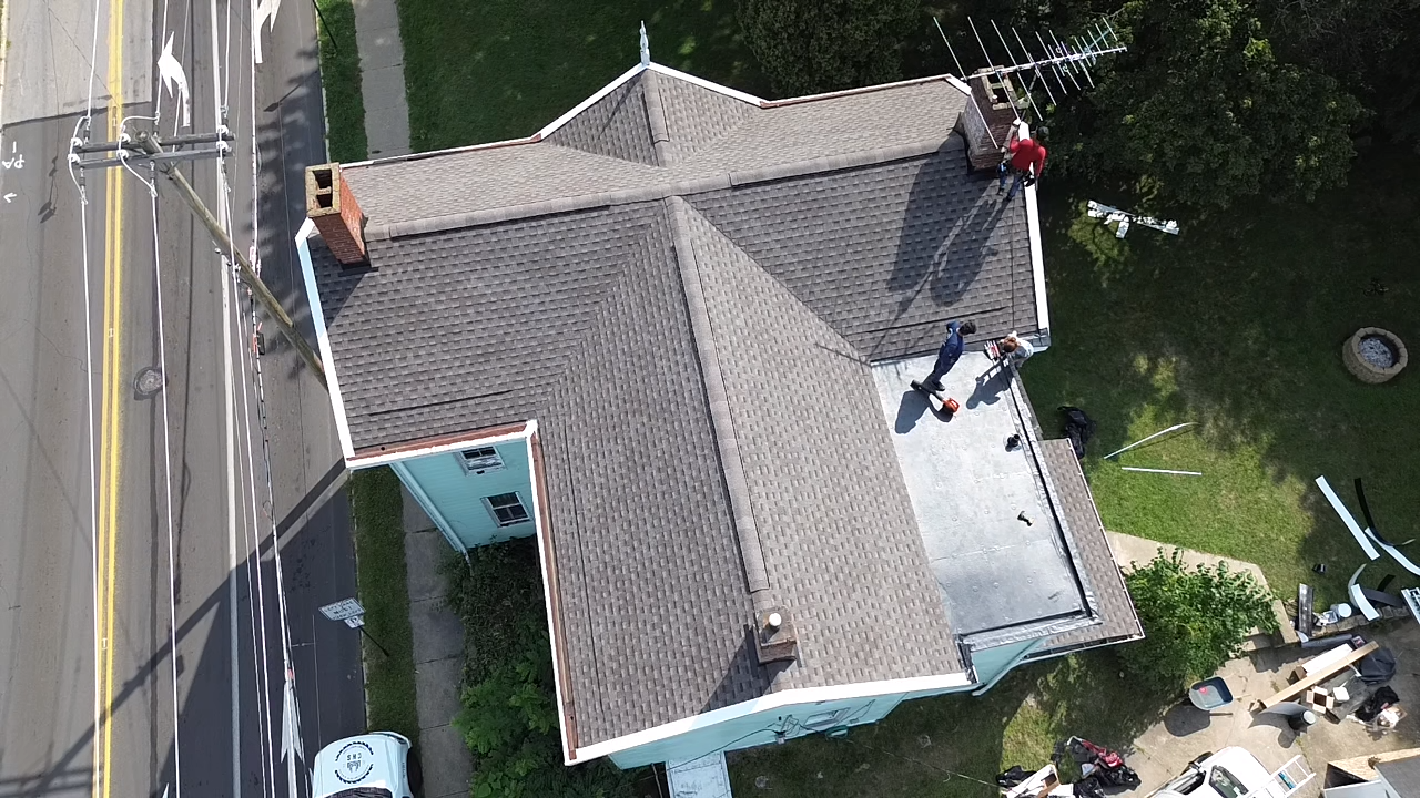 Certified roofing contractor in Monroeville, PA repairing asphalt shingles